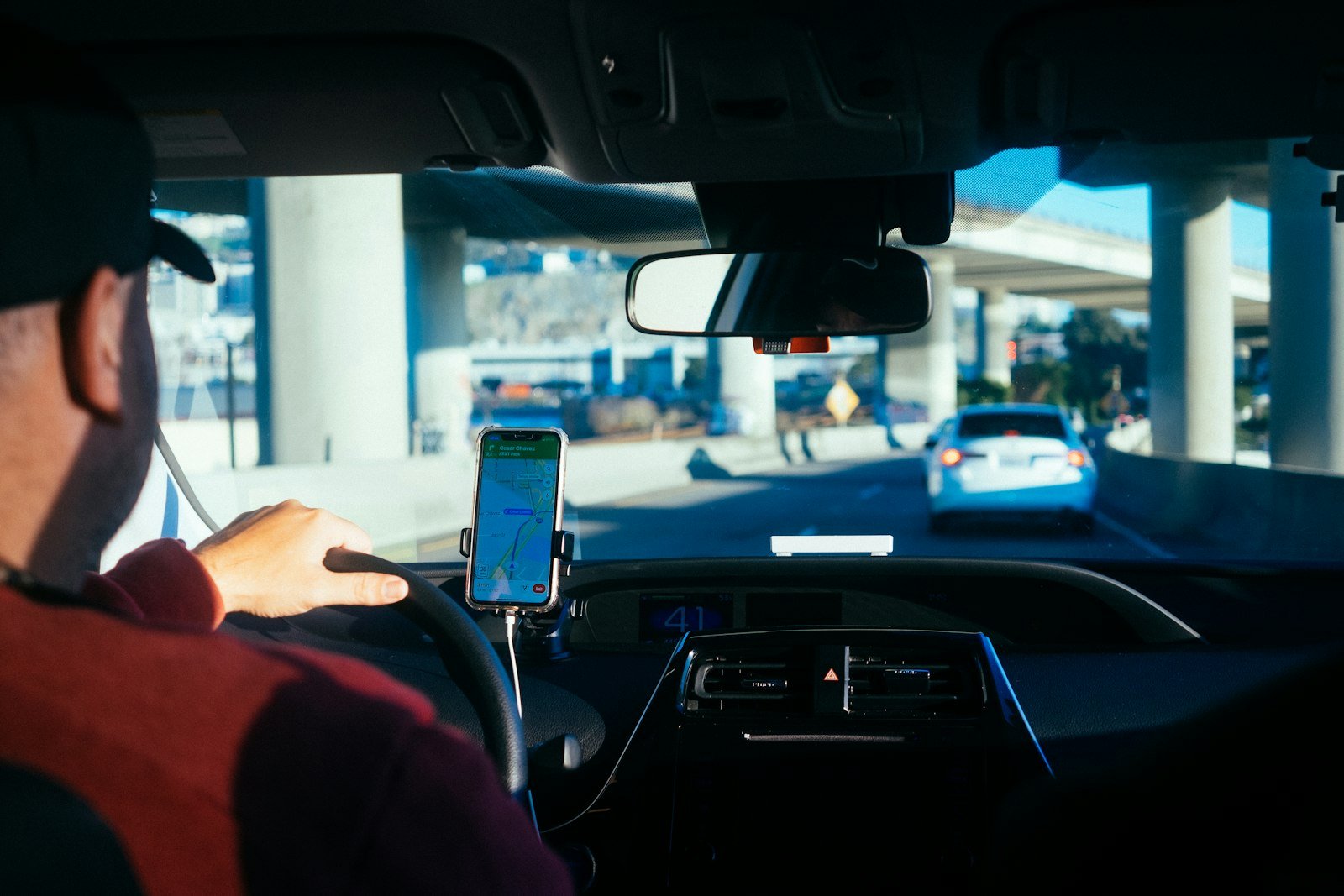 Rideshare driver using a phone navigation app on the dashboard